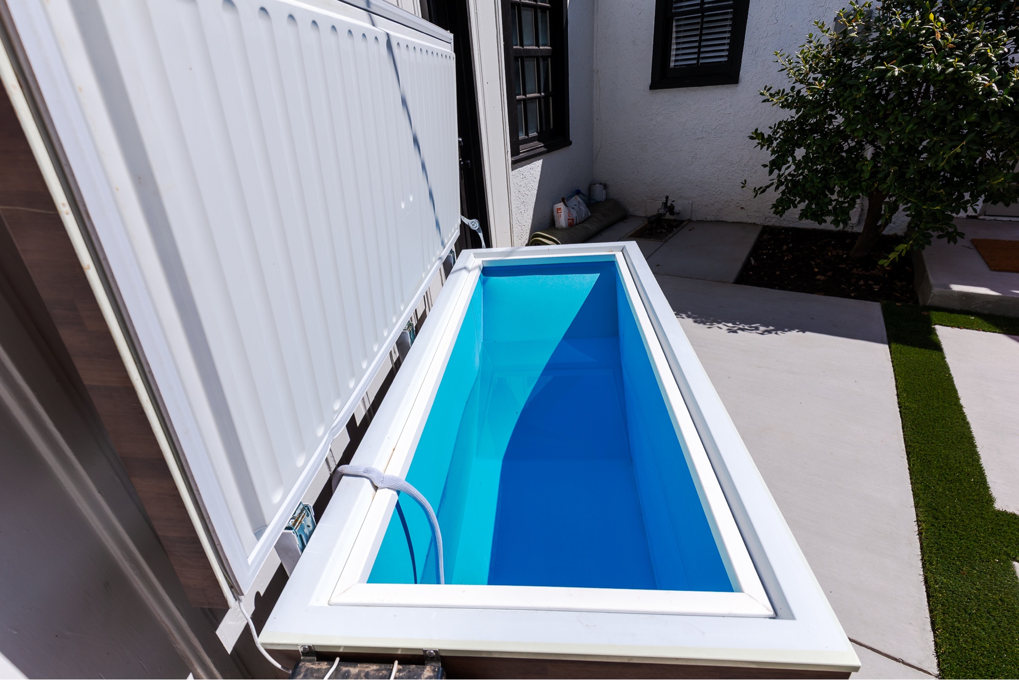 White cold plunge tub in a side yard
