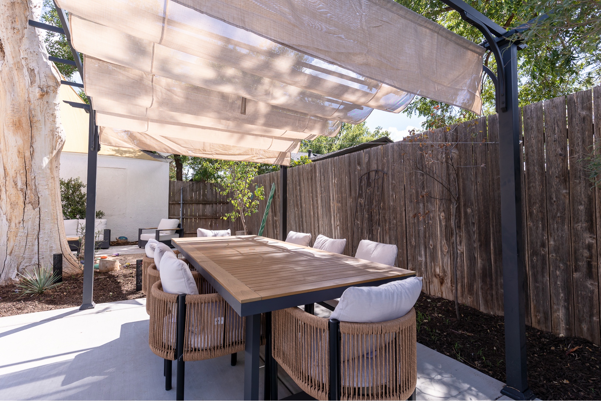 Wave-canopy pergola over teak dining table