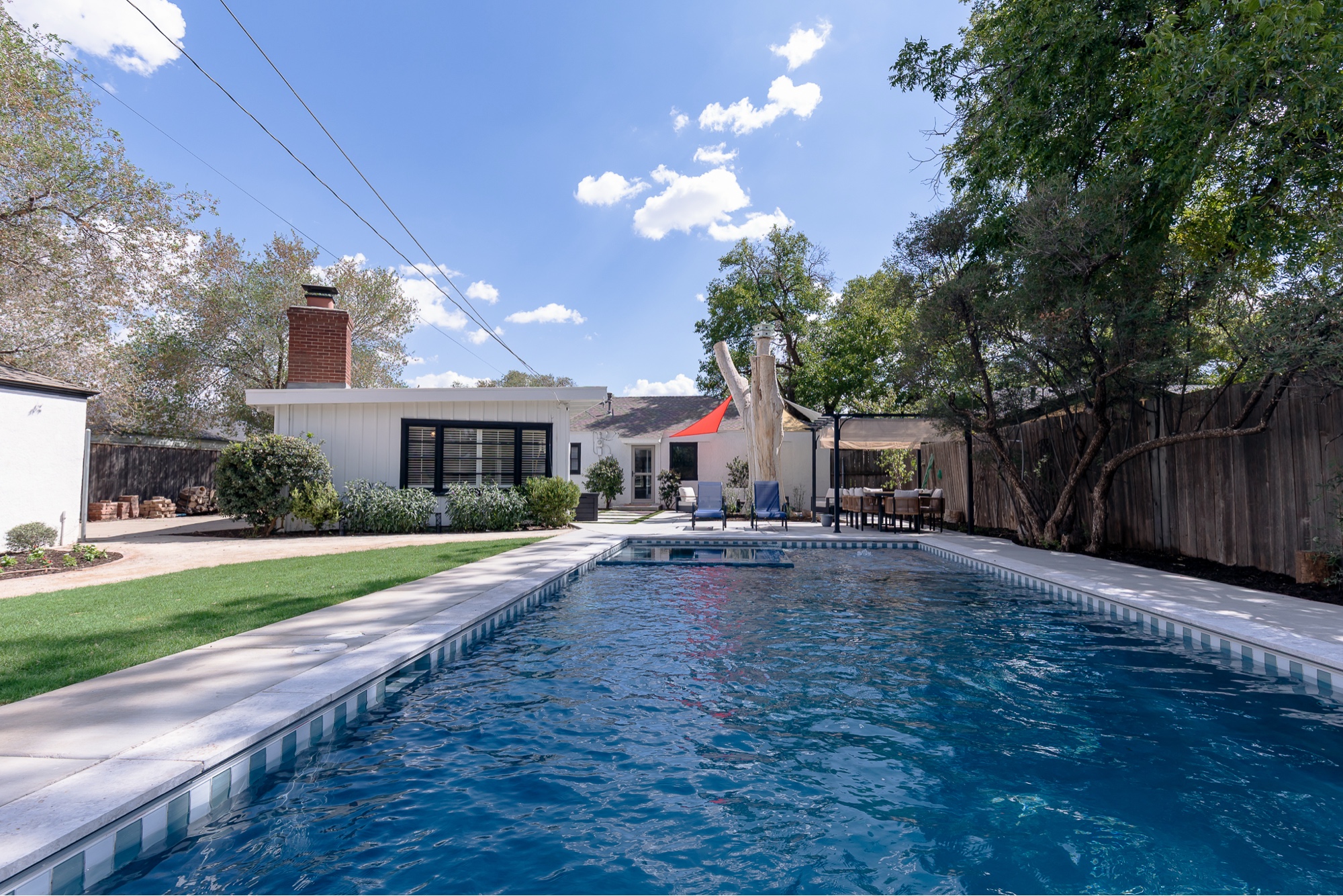 Full-length backyard swimming pool with classic cabana-stripe tile
